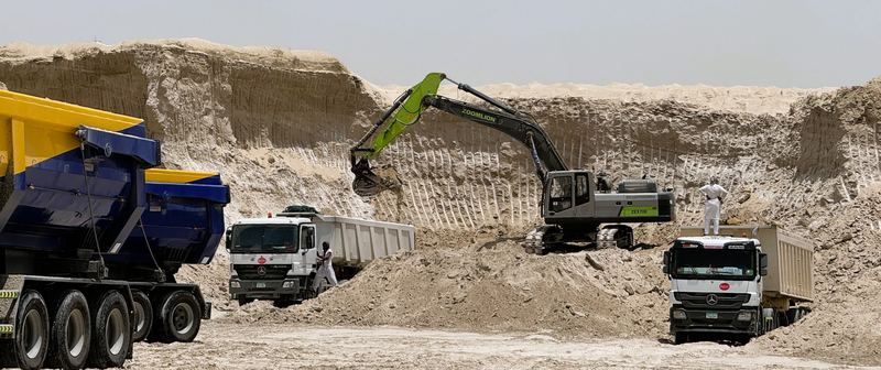 Excavator loading a tipper truck at a borrow pit