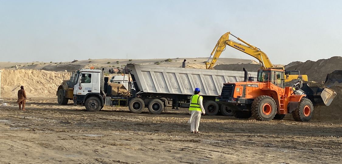 Wheel loader and excavator loading a company tipper truck on site
