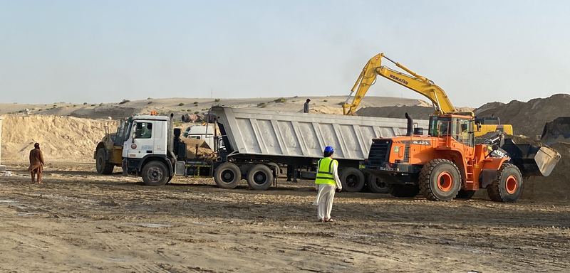 Wheel loader and excavator loading a company tipper truck on site